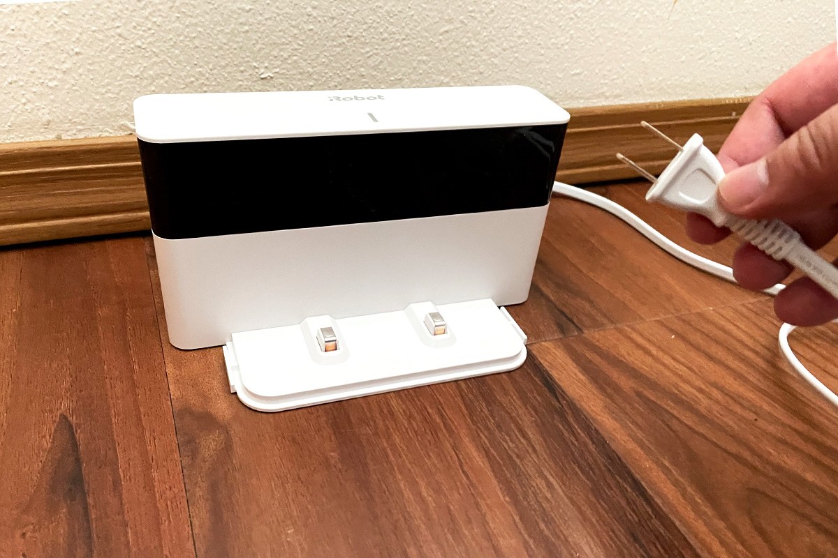 Person holding plug of Braava Jet M6 Charging Deck