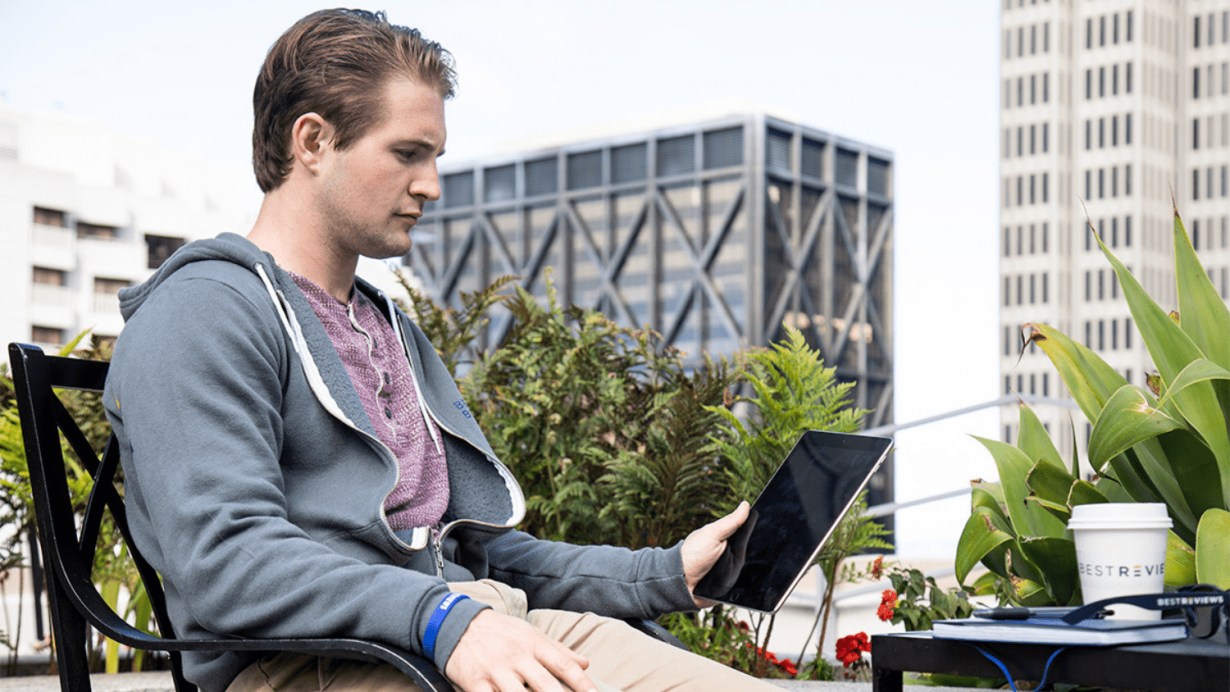 Person sitting at table outdoors using Apple iPad Air Person sitting at table outdoors using Apple iPad Air
