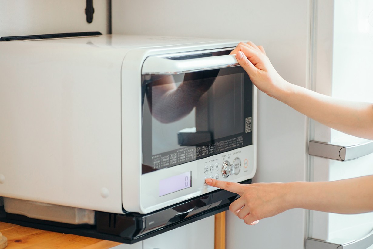 a person operating a steam toaster oven