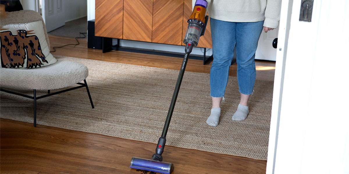 Person using Dyson V15 Detect on hardwood floor